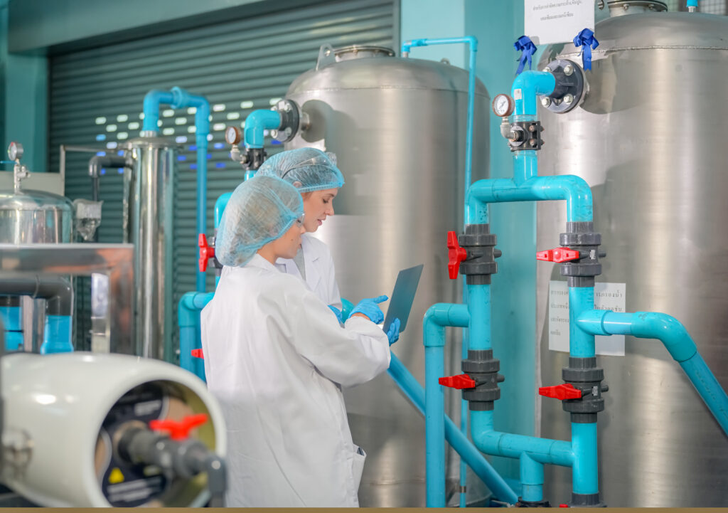 Ouvrière inspectant une bouteille d'eau sur une ligne de production en usine Ouvrière inspectant une bouteille d'eau sur une ligne de production en usine